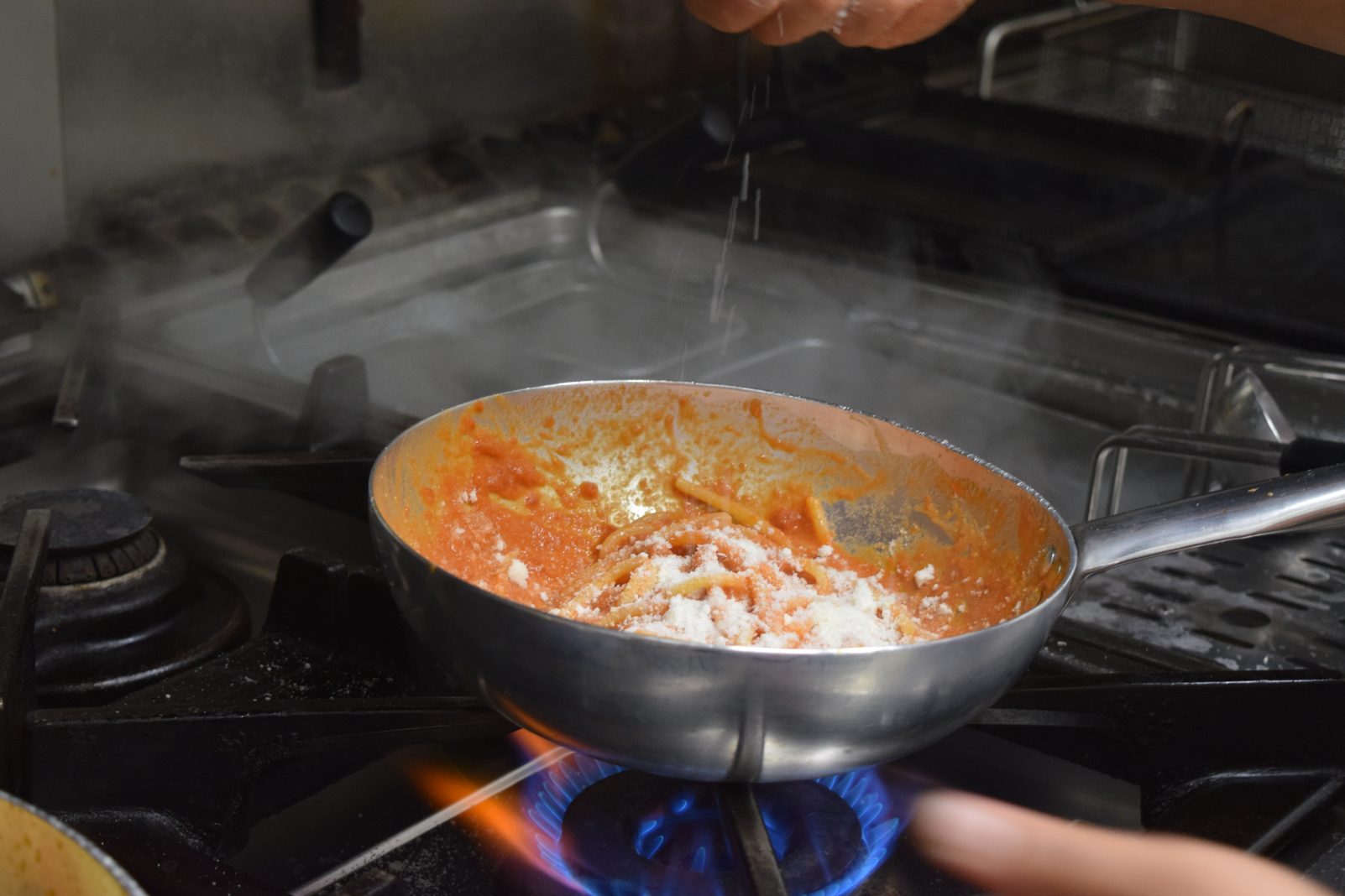 Padella sulla fiamma viva nella cucina del ristorante
